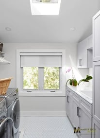 Victoria-Custom laundry room renovation with white shaker cabinets and skylight