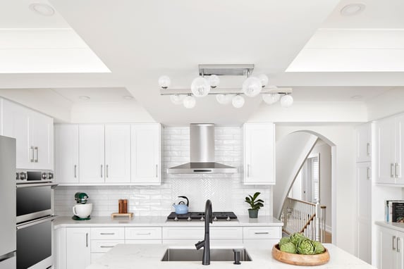 White modern kitchen with herringbone style backsplash blue island and barstools in Markham renovation